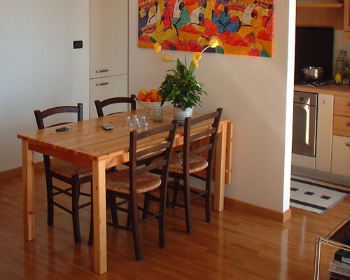 casa lella - la zona cucina schermata da un setto a tutta altezza e la zona pranzo